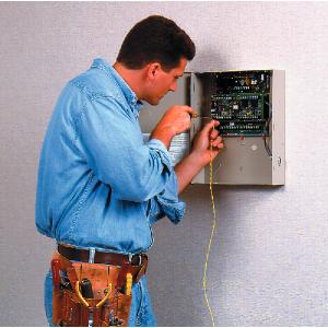 Installer fitting a Honeywell alarm system.